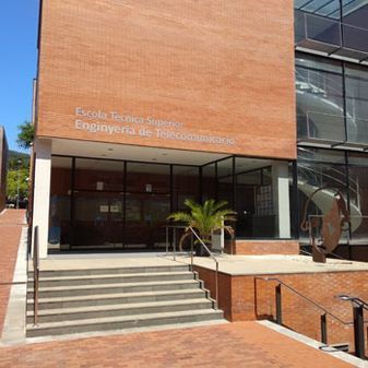 Edificio de ladrillo con entrada, escaleras y texto 