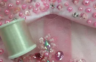 Vaaleanpunaisia koristehelmiä ja lankaa