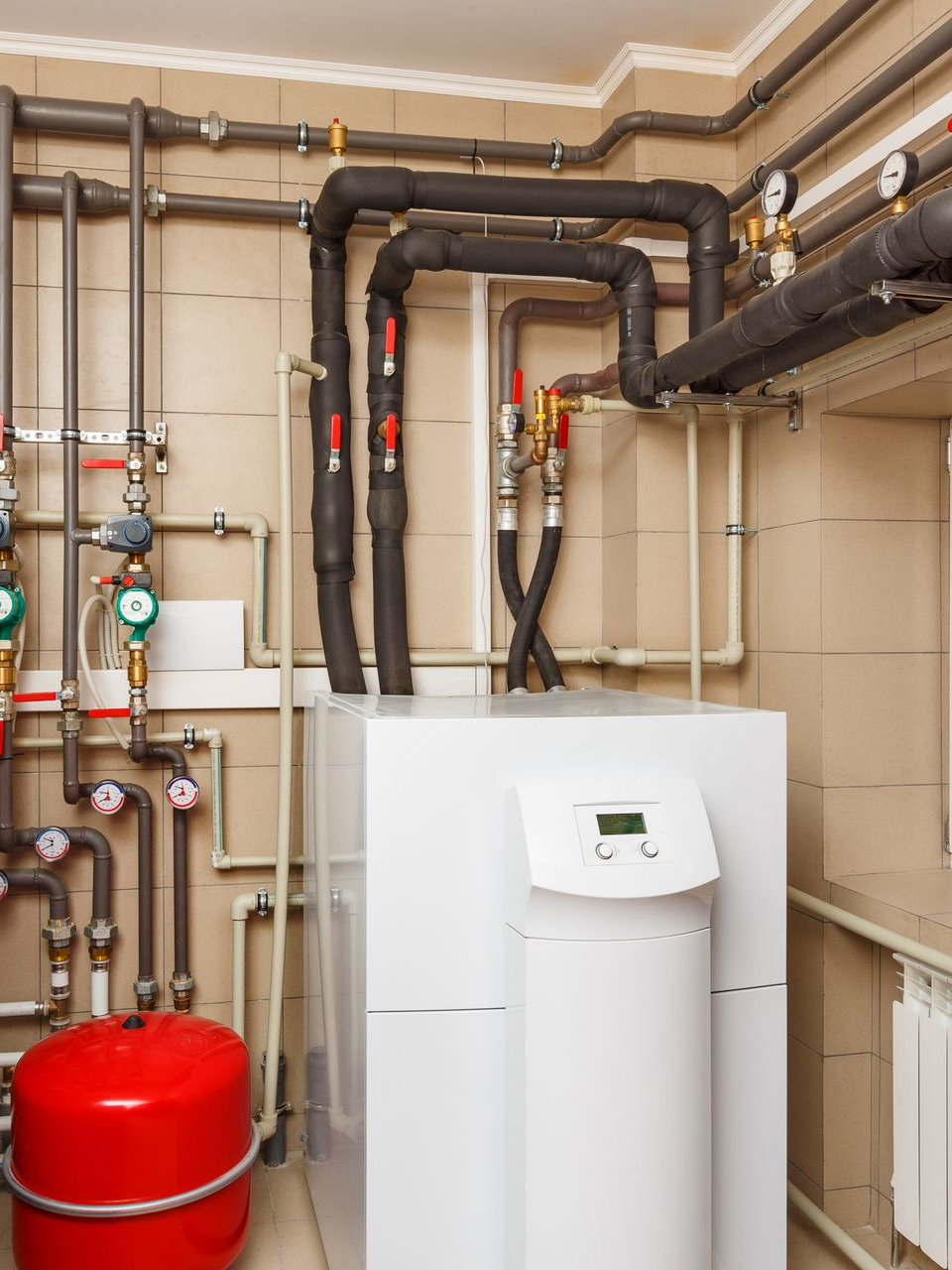 Une pompe à chaleur avec tuyauterie dans une buanderie.