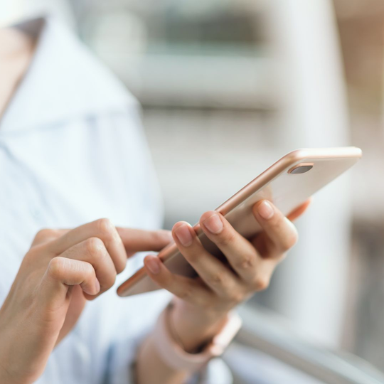 Personne qui tient un smartphone entre ses mains.