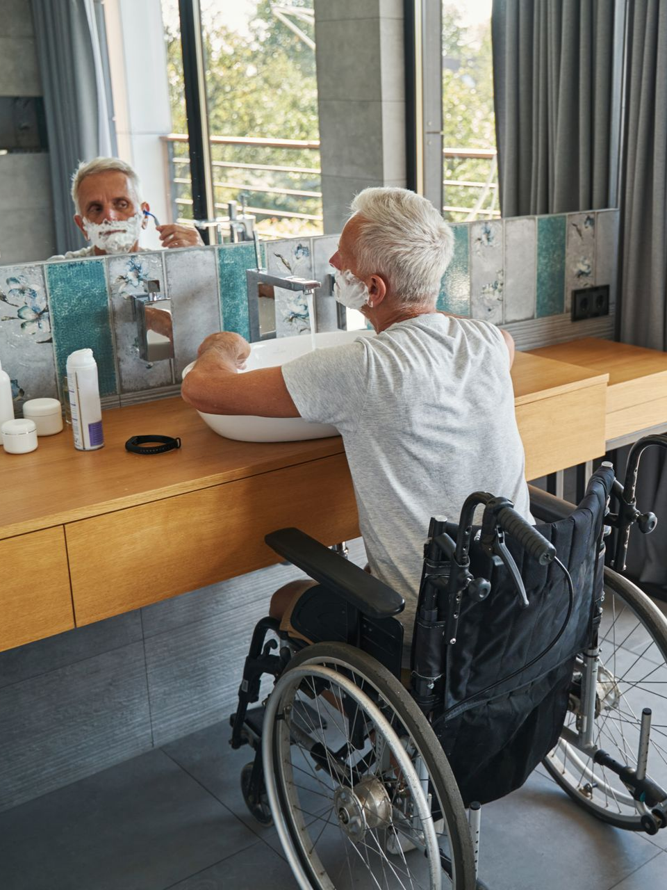 Un homme en fauteuil roulant qui se rase la barbe.