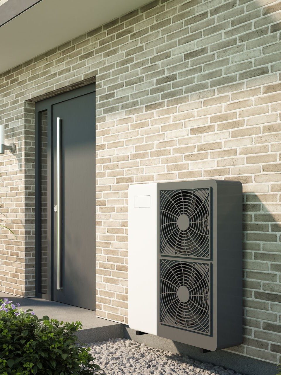 Unité de pompe à chaleur fixée sur un mur de briques à côté d'une porte grise.