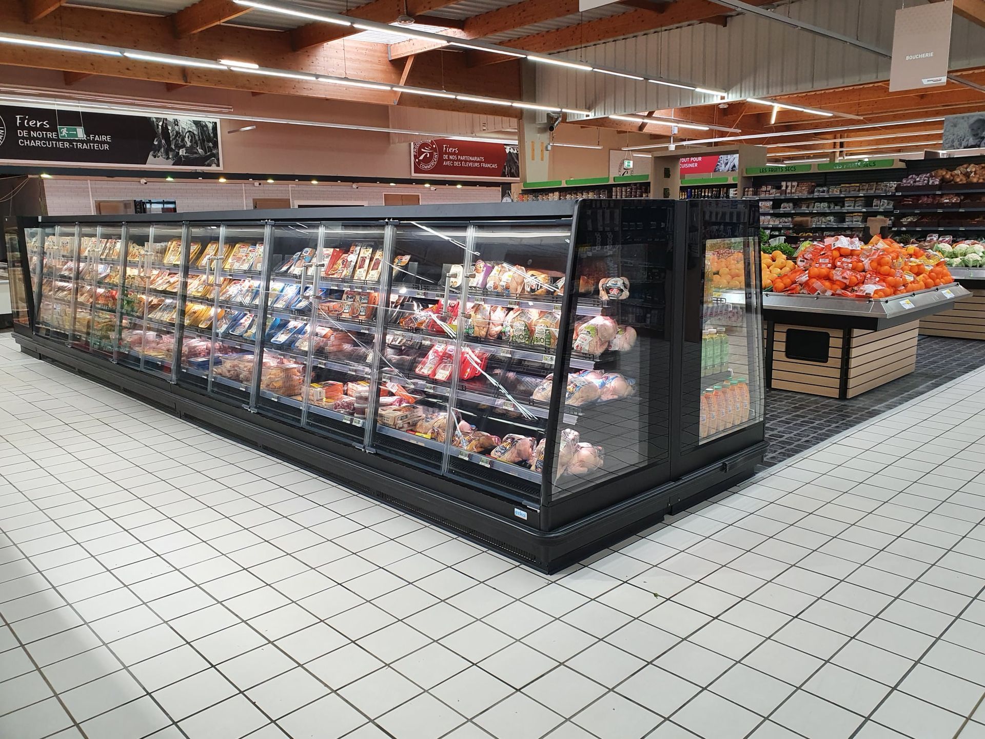 Une vitrine réfrigérée remplie de produits alimentaires dans une allée de supermarché.