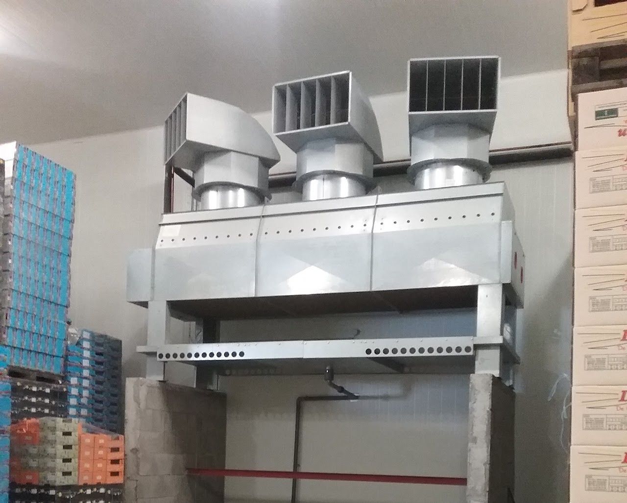Système de ventilation industrielle métallique avec trois conduits d'évacuation, dans une zone de stockage.