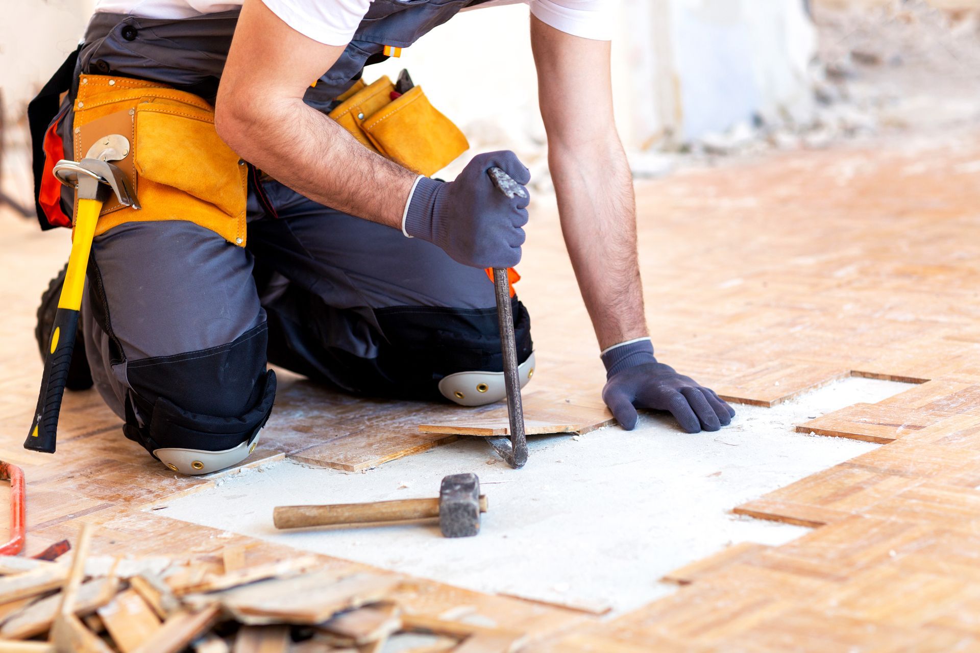 Un homme arrachant des lattes de parquet