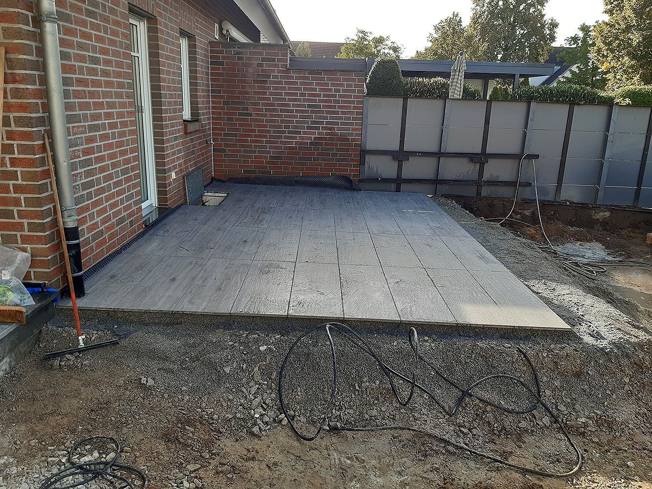 Ein Backsteinhaus mit einer Kiesauffahrt davor.