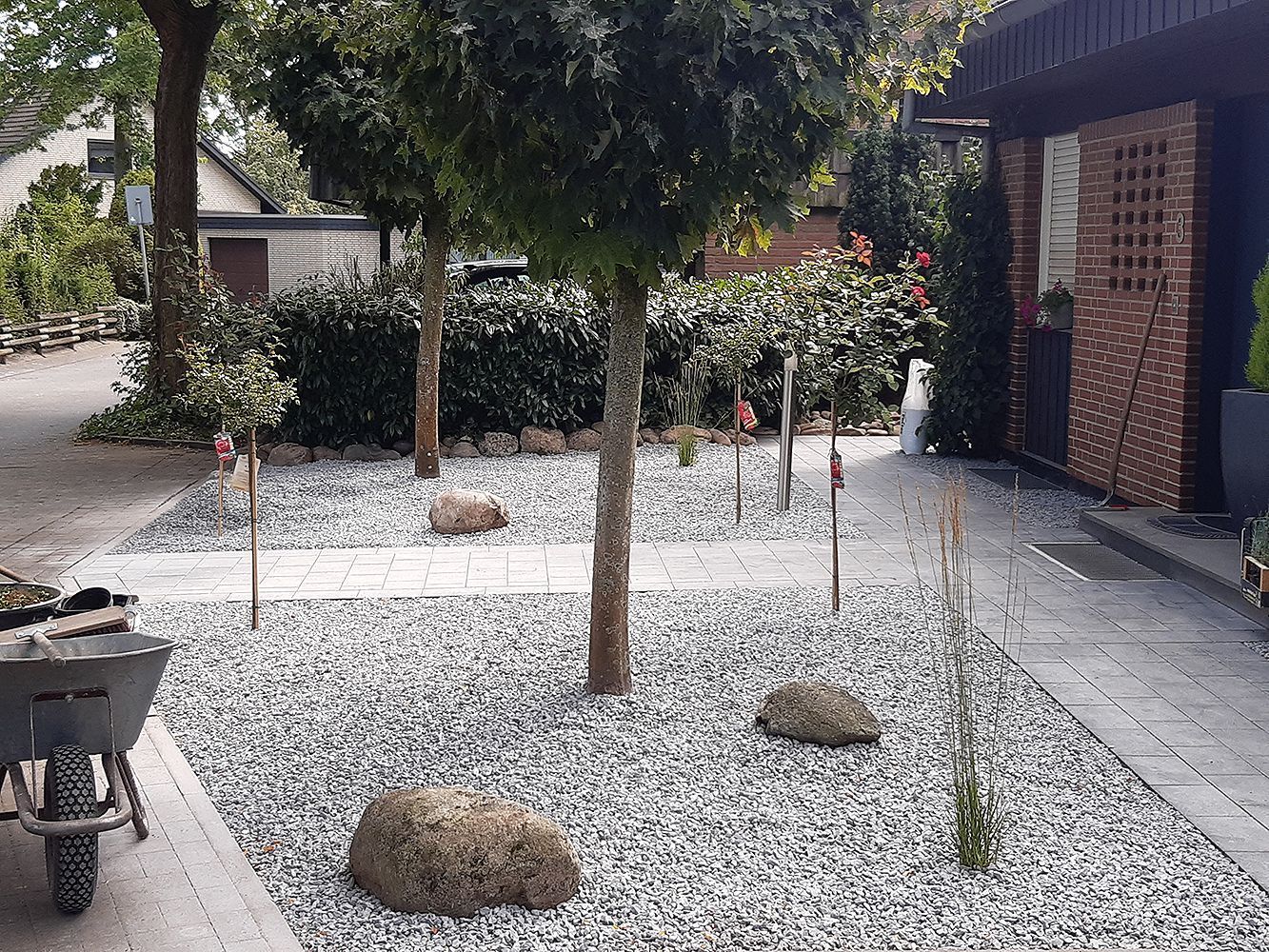 Eine Schubkarre steht mitten in einem Kiesgarten.