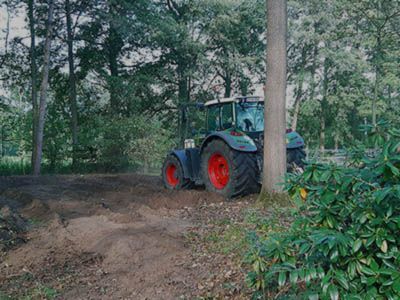 Ein Traktor mit roten Rädern fährt durch einen Wald