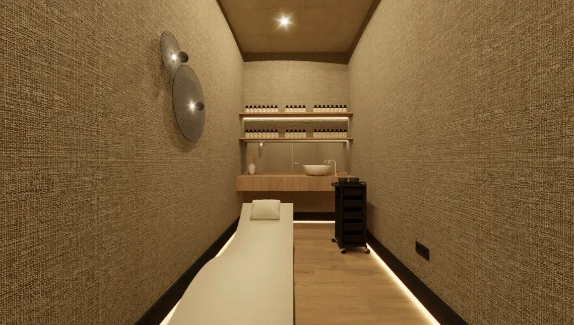 Sala de tratamiento de spa con paredes marrones texturizadas, mesa de masajes, lavabo