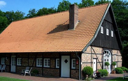 Ein Backsteinhaus mit Ziegeldach und Schornstein