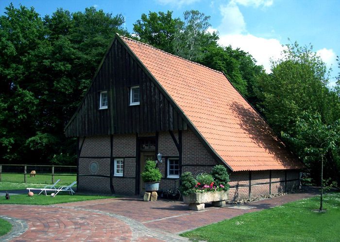 Ein Haus mit einem roten Ziegeldach und einer gemauerten Auffahrt