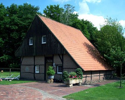 Ein Haus mit einem roten Ziegeldach und einer gemauerten Auffahrt