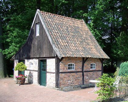 Ein kleines Backsteingebäude mit einem Holzdach