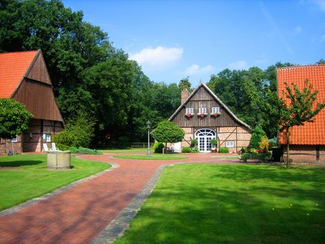 Ein Haus mit einem roten Dach ist von Gras und Bäumen umgeben