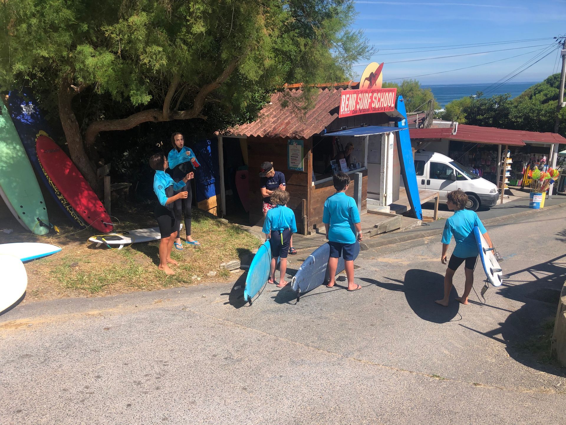 Groupe d'enfants attendant leur cours de surf devant l'école