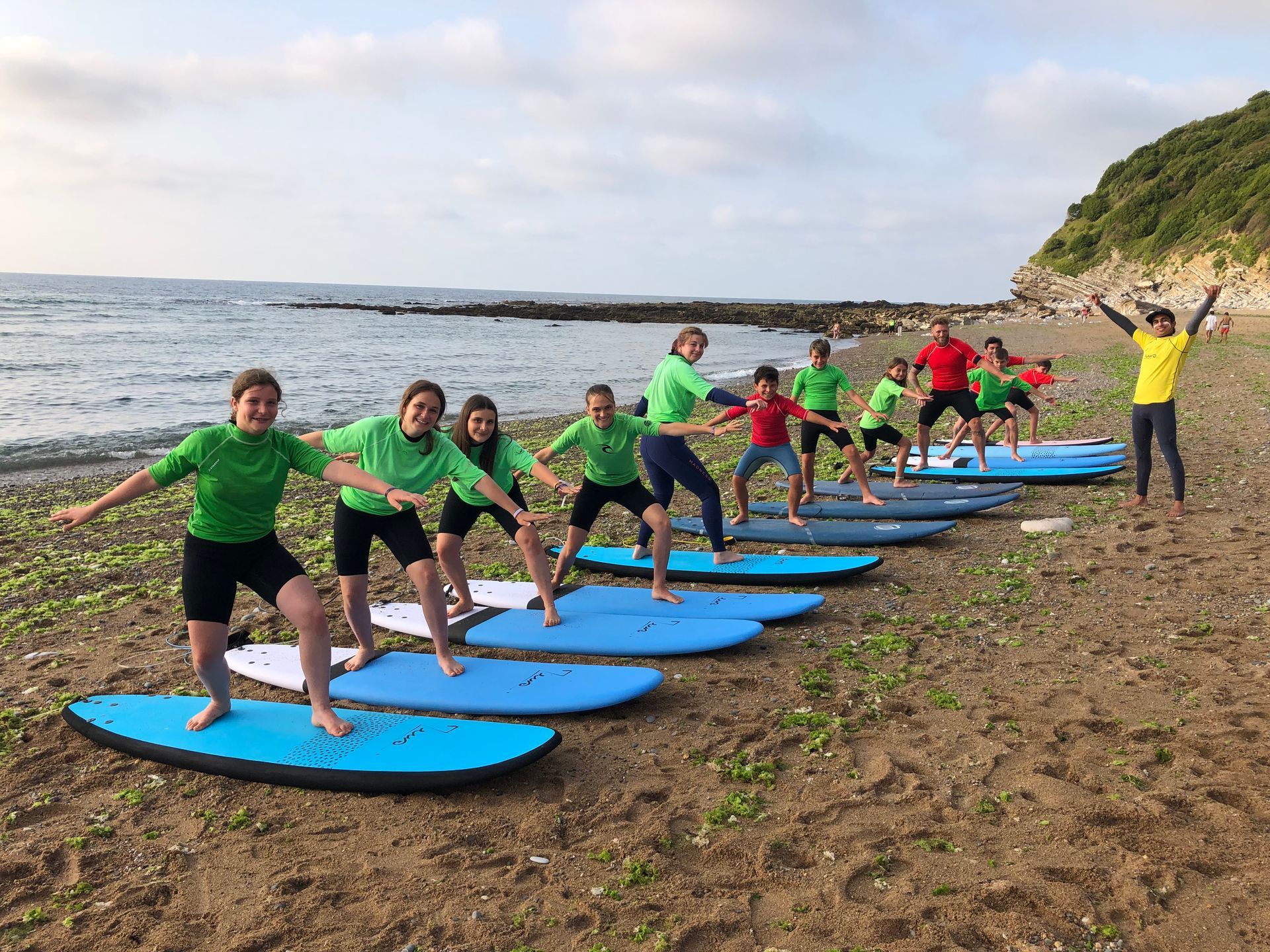 Elèves sur leur planche de surf posée sur le sable