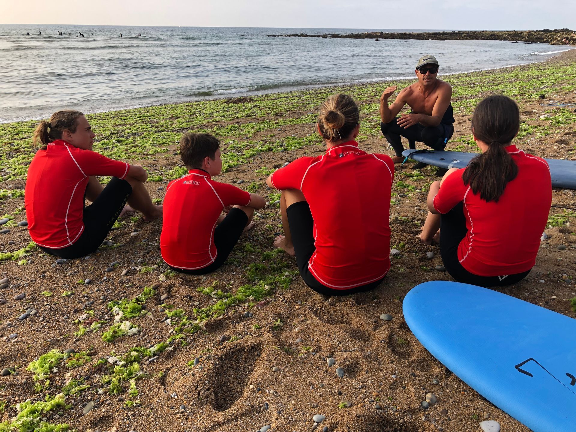 4 jeunes assis sur le sable avec le professeur