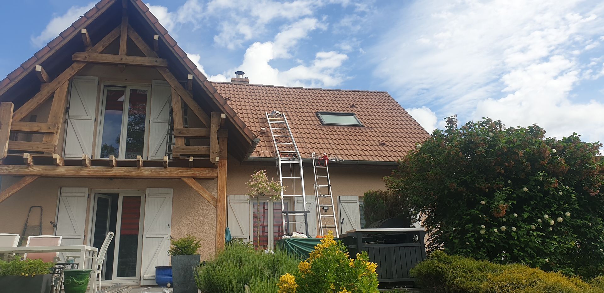 Photo d'une maison vue de face avec une échelle qui va sur le toit