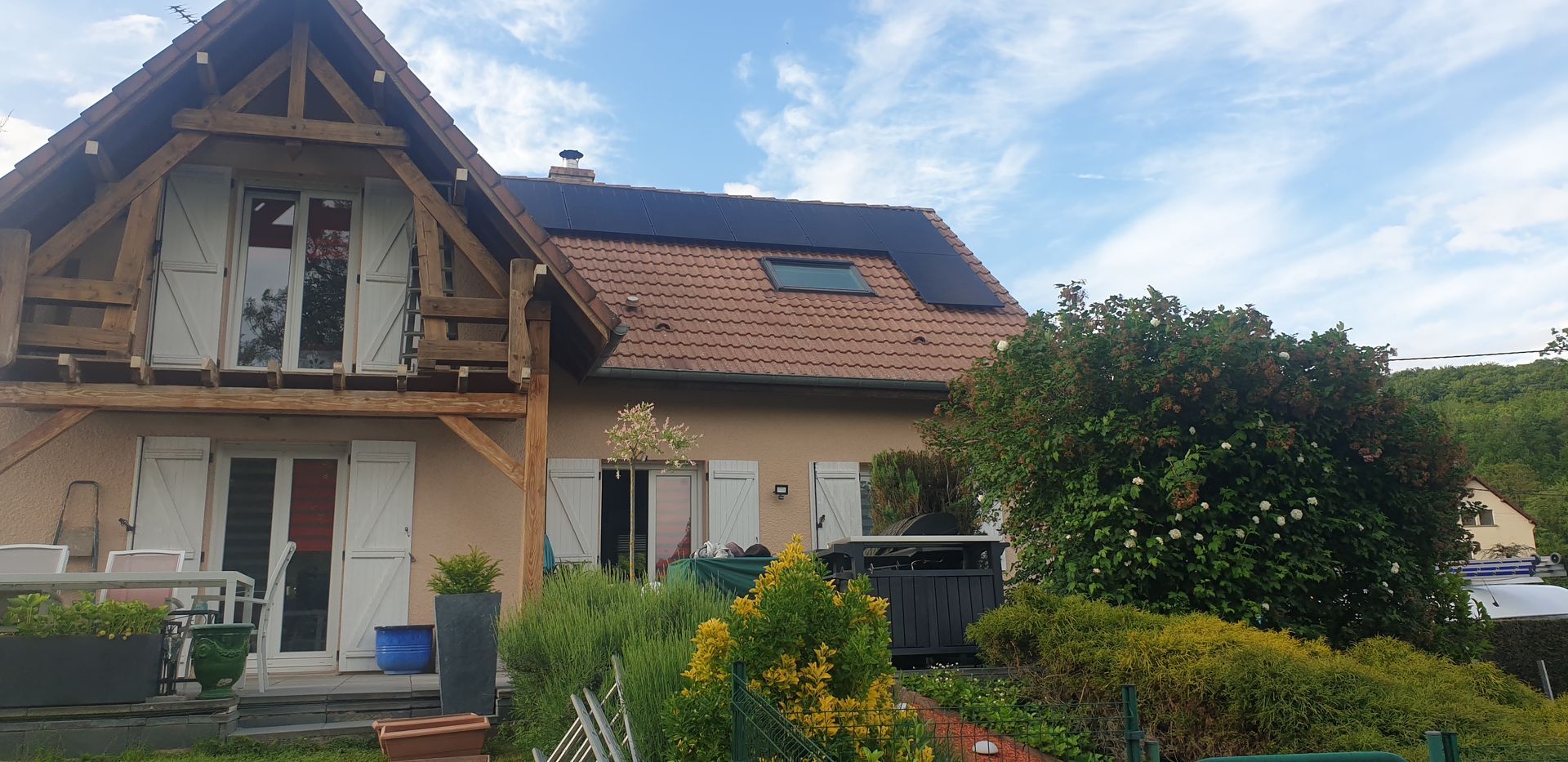 Photo d'une maison vue de face avec des panneaux solaires sur le toit