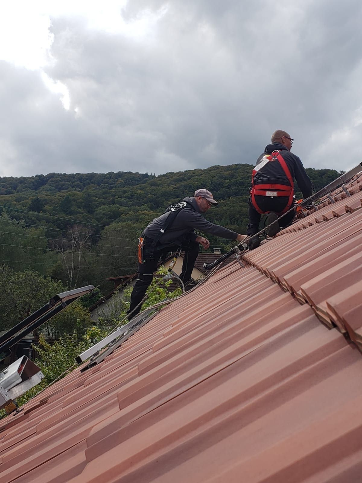 Photo de deux artisans sur le toit d'une maison