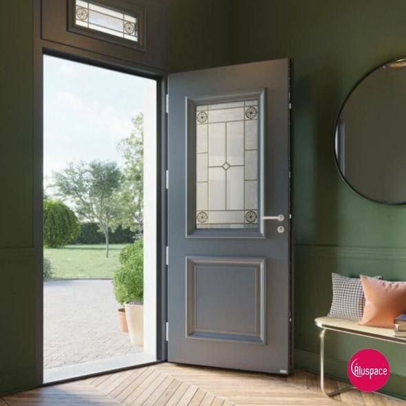 Double porte blanche à panneaux de verre dépoli dans une pièce avec une lampe trépied, des œuvres d'art et un sol foncé.