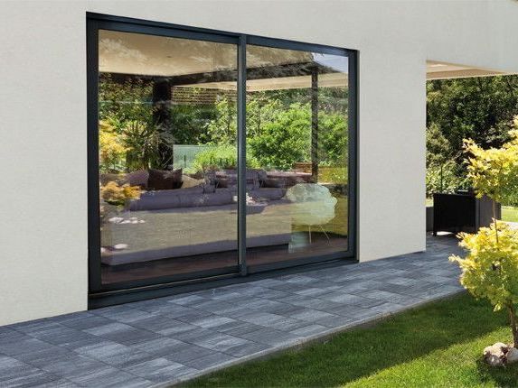 Baie vitrée donnant sur une terrasse qui longe une maison