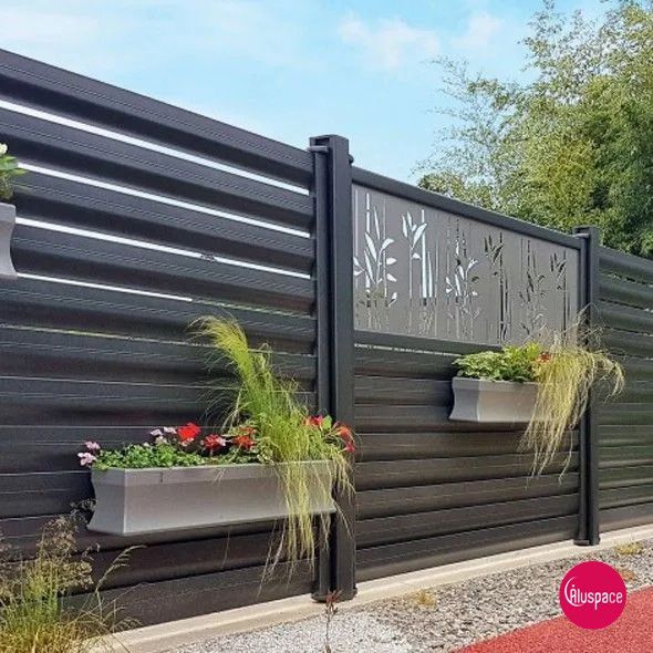 Clôture en aluminium entouré de plantes vertes