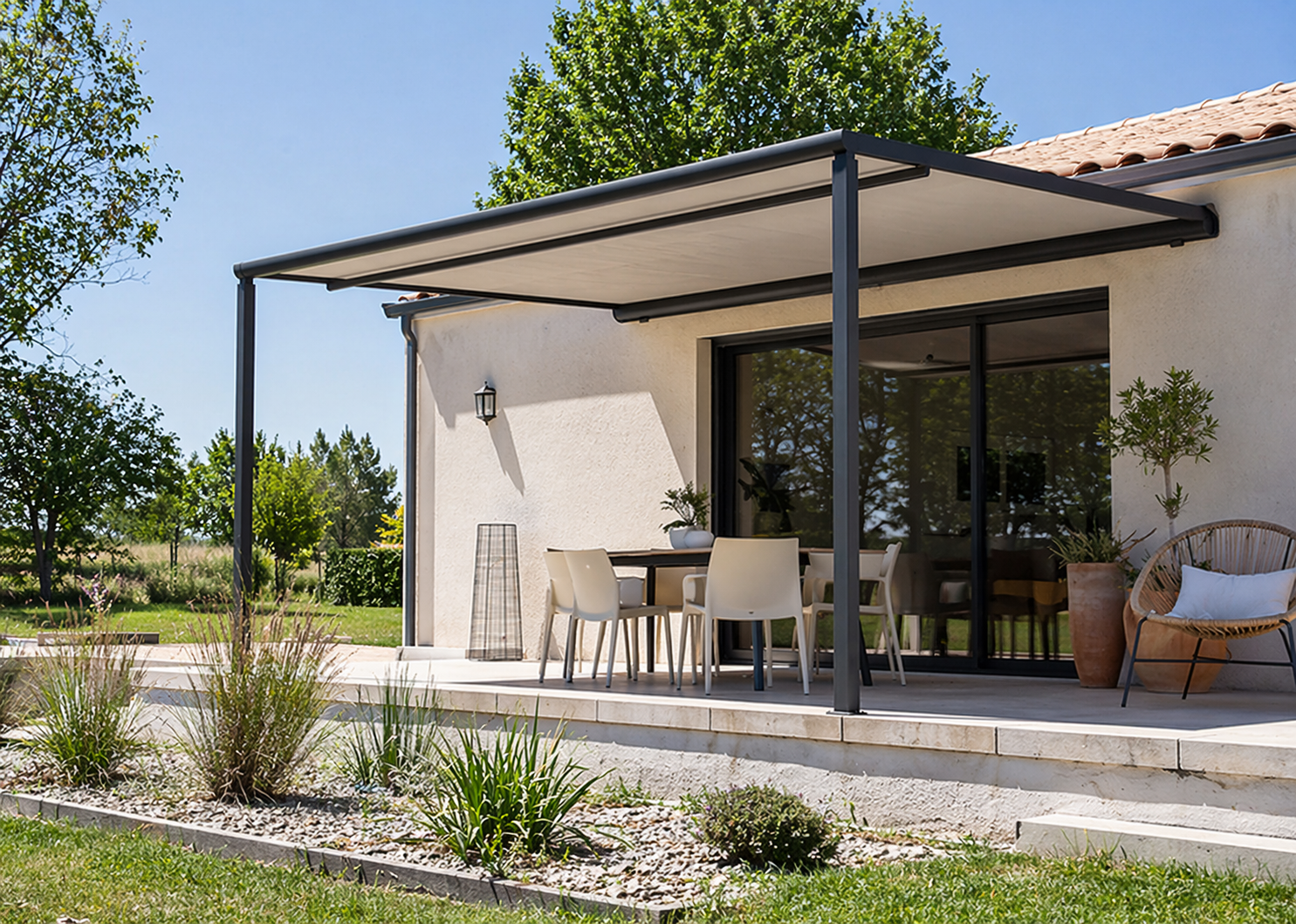 Pergola surplombant un patio avec des sièges, reliée à un bâtiment doté de portes vitrées et offrant une vue panoramique.