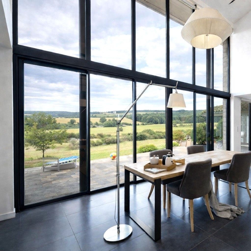 Villa avec une immense baie vitrée donnant sur une terrasse et une piscine