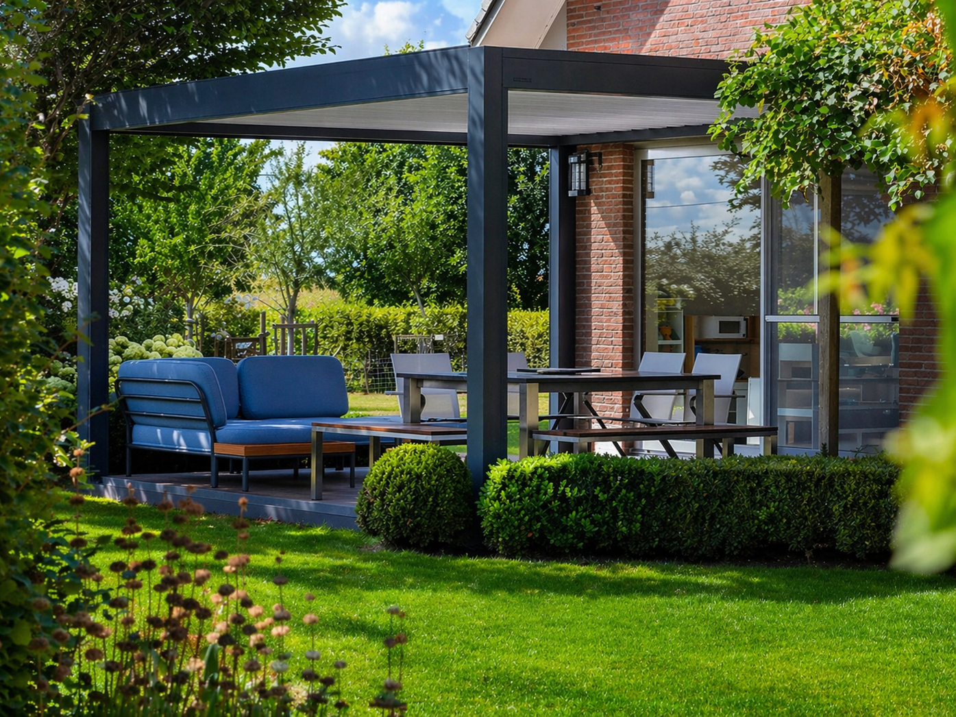 Terrasse extérieure avec pergola bleu foncé, sièges, table à manger et pelouse.