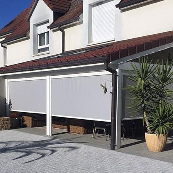 Maison moderne avec stores solaires gris.