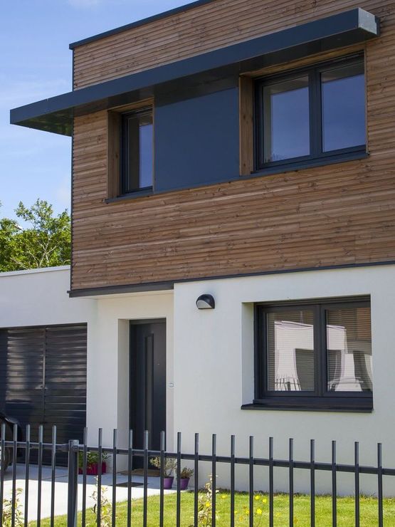 Maison moderne avec bardage en bois, menuiseries en aluminium anthracite et clôture