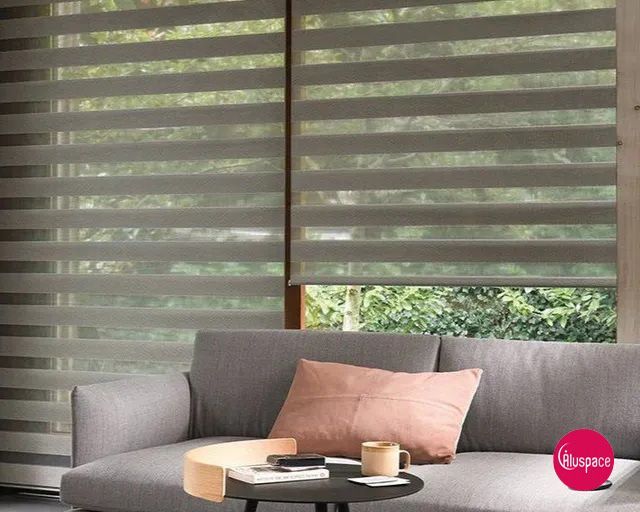 Salle de bains moderne avec stores à double couche aux fenêtres, baignoire îlot et grand miroir rond.