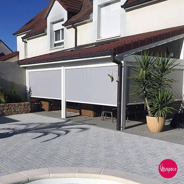 Maison moderne avec stores solaires gris.