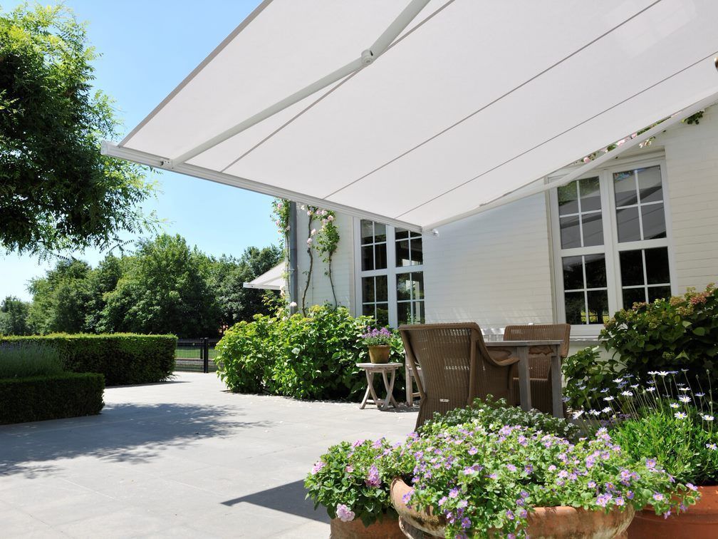 Store blanc déplié au dessus d'une terrasse