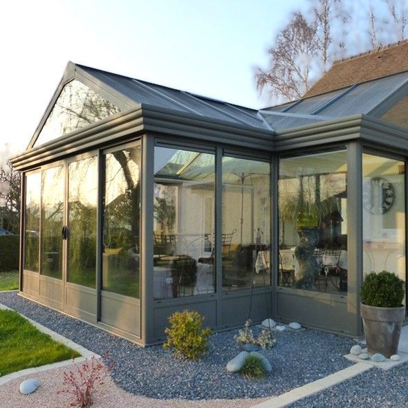 Véranda entourée d'aménagements paysagers