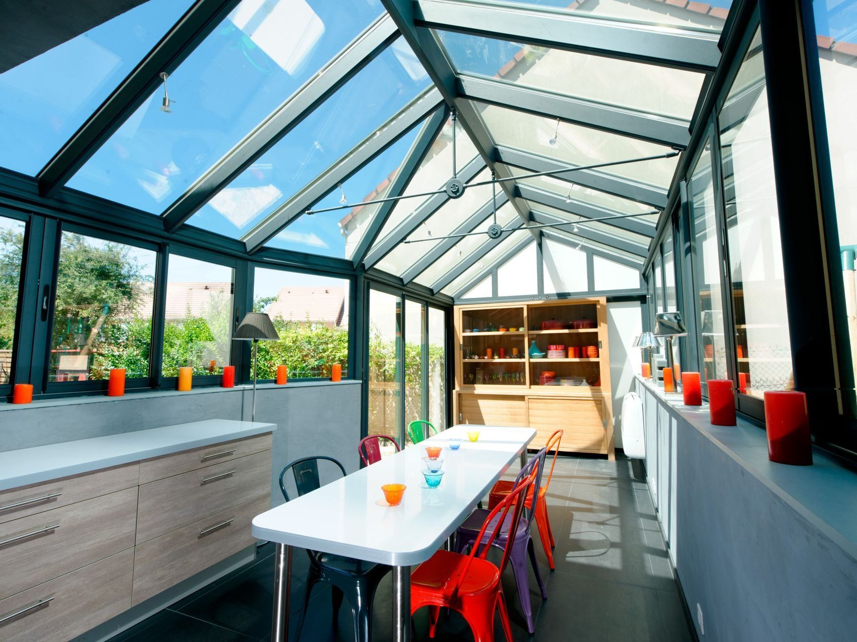 Véranda aménagée avec meubles et vaisselle multicolore
