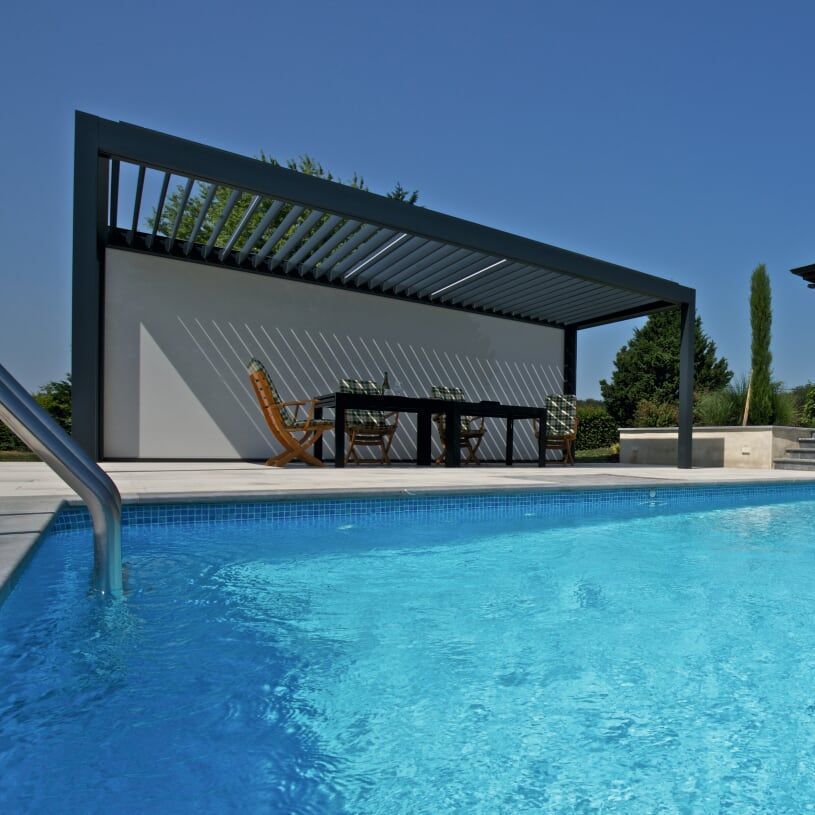 Pergola bioclimatique au bord d'une piscine