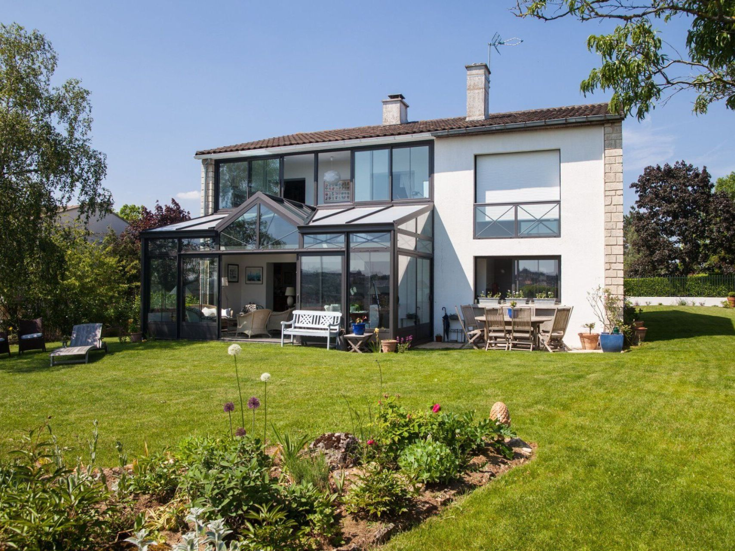 Maison avec véranda et jardin fleuri