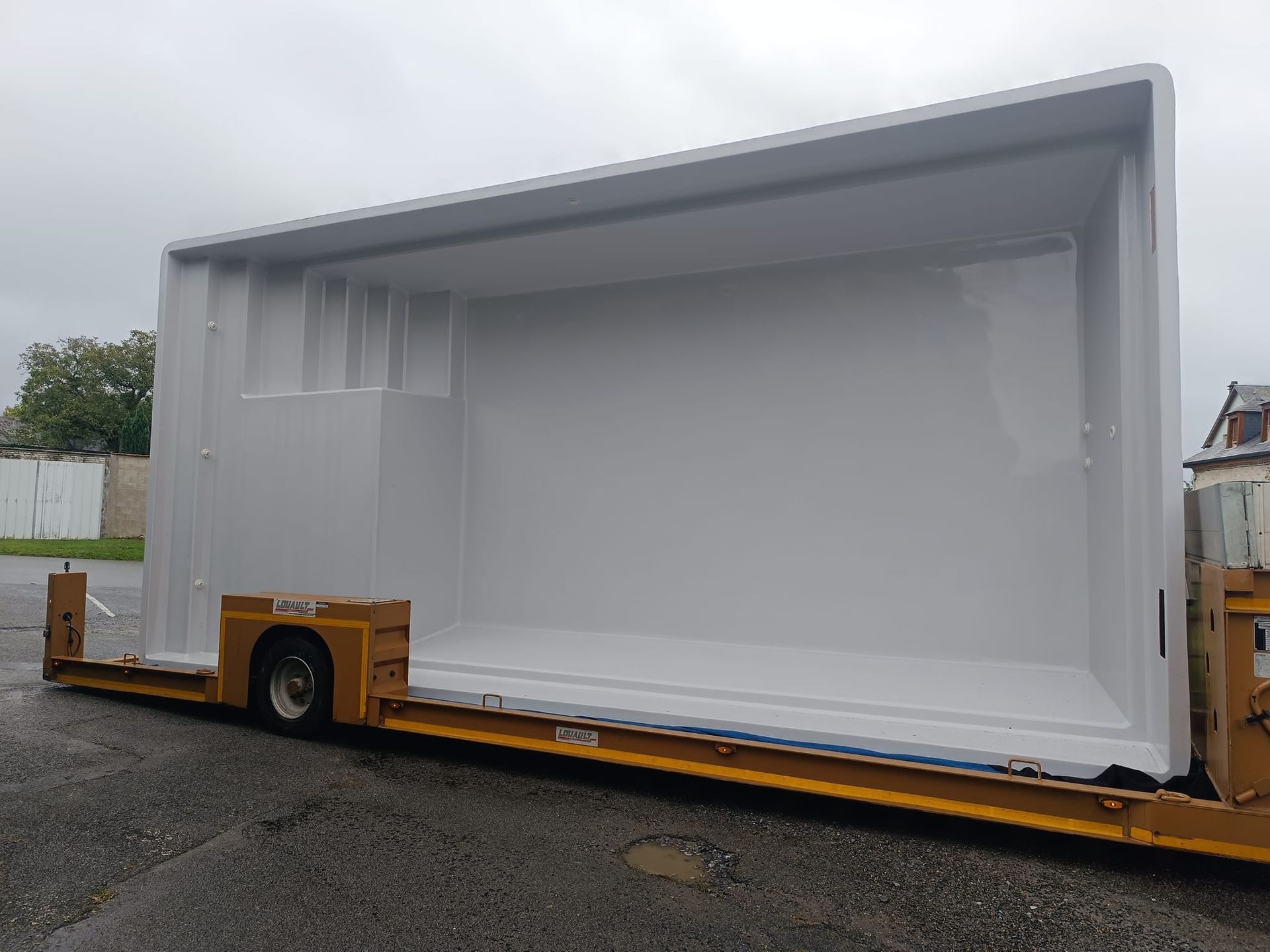 Coque de piscine transportée sur un camion.