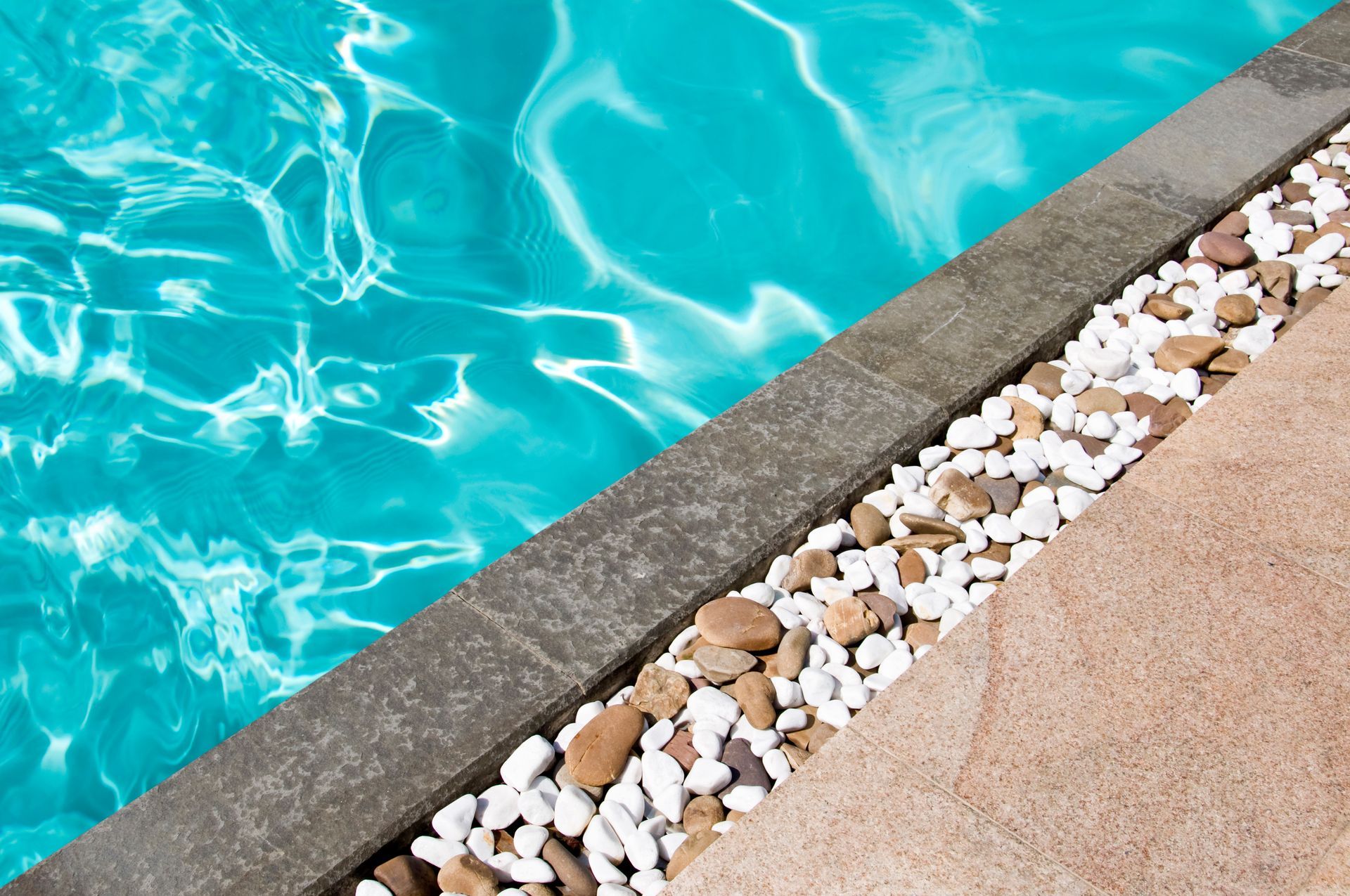 Carrelage et gravier autour d'une piscine.