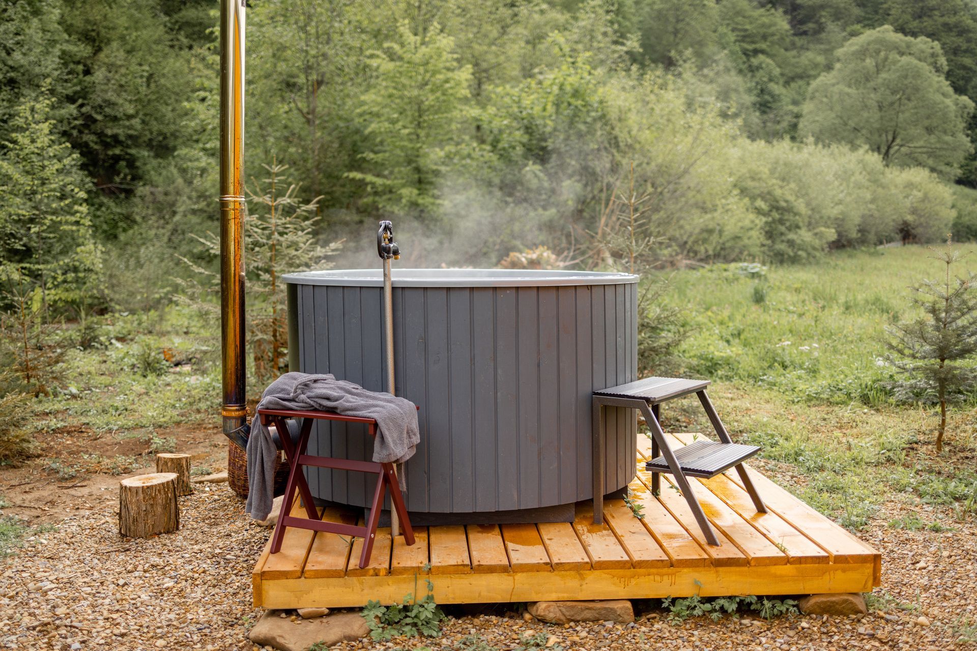 Bain nordique posé sur une terrasse en bois.