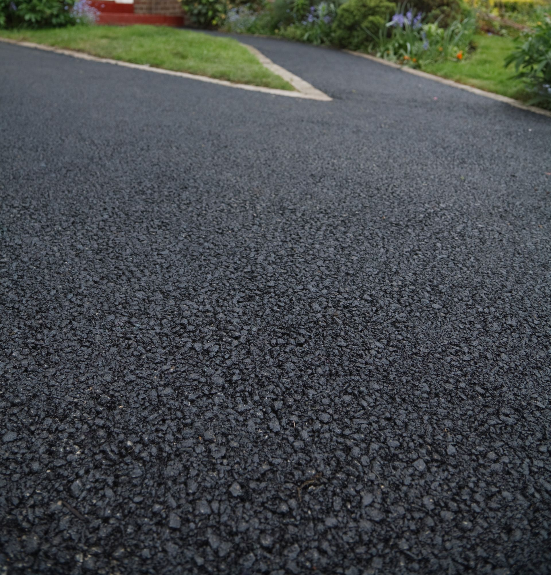 Un accès à la maison recouvert d'un enrobé.