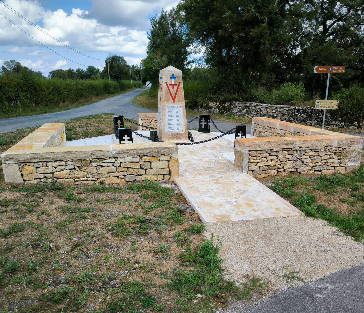 Un monument aux morts en pierre, entouré d'une chaîne.