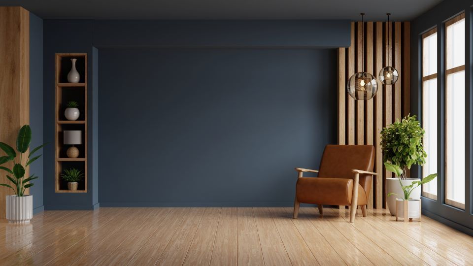 Ein leeres Wohnzimmer mit einem Stuhl, Pflanzen, Regalen und Fenstern.