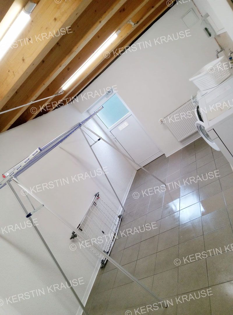 Ein Raum mit einem Wäscheständer und einem Fenster.