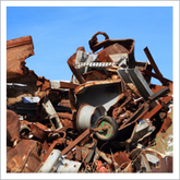 Pila de chatarra oxidada contra un cielo azul.