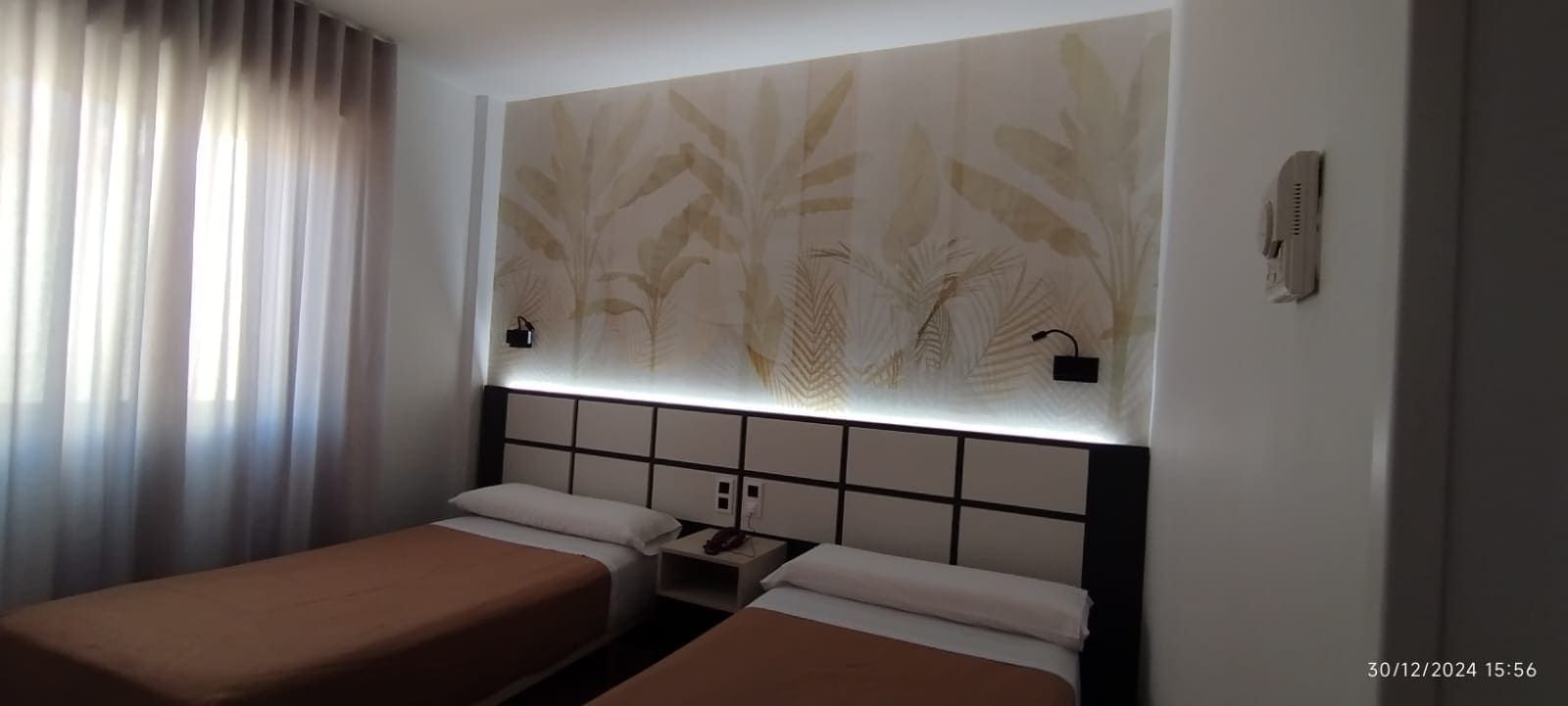 Camas individuales en una habitación de hotel con decoración en tonos tostados