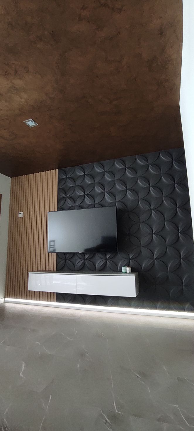 Televisor pequeño sobre un soporte blanco contra una pared oscura texturizada en una habitación sencilla.