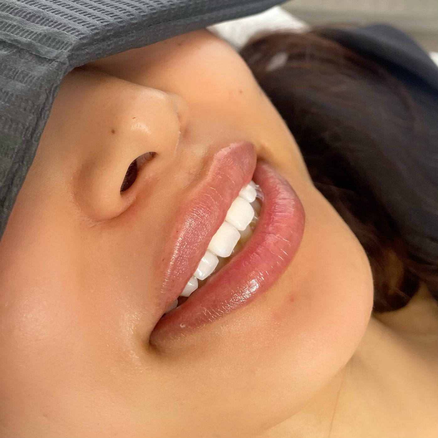 Eine Nahaufnahme des Mundes einer Frau mit weißen Zähnen und rosa Lippen.